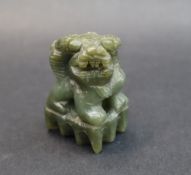 A Chinese hardstone dog of foo figure, seated on a platform,