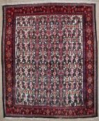 An Iranian rug with a rectangular cream field and interlocking pattern to multiple guard stripes