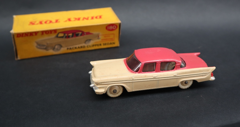 A Dinky Toys 180 Packard Clipper Sedan with windows having a cerise upper body,