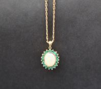 An emerald and opal pendant of oval form set with a central opal and nineteen emeralds to yellow