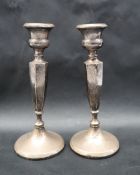 A pair of George V silver candlesticks, with hexagonal tapering columns on a spreading foot,