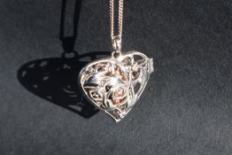 A Clogau silver hinged heart shaped pendant with suspended yellow metal angel on a white metal