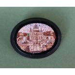 A micromosaic brooch of oval form depicting a classical building in a white metal mount,