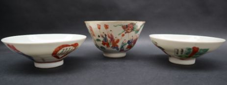 A Chinese porcelain tea bowl decorated with figures holding aloft a dragon, seal mark to the base,