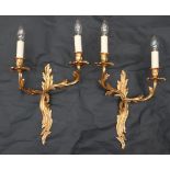 A pair of gilt metal twin branch wall sconces, of scrolling leaf form,