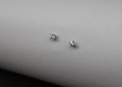 A pair of solitaire diamond earrings, each round brilliant cut diamond approximately 0.