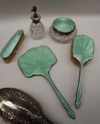 A George V silver and green enamel decorated part dressing table set including a clothes brush,