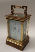 A 20th century brass cased carriage clock, with a circular dial with Roman numerals and alarm dial,