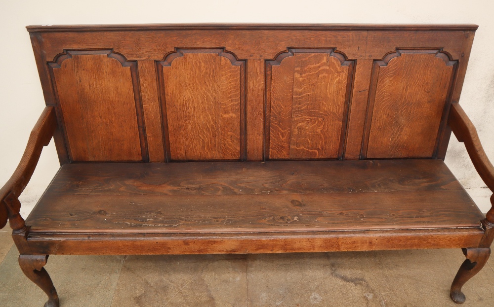 An 18th century oak settle with a four panel back and solid seat on cabriole legs and pointed pad - Image 2 of 6