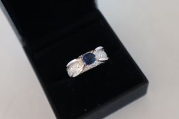 An 18ct white gold sapphire and diamond ring set with a central sapphire and numerous round