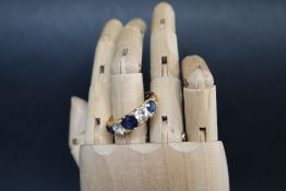 A Sapphire and diamond line ring set with three sapphires and two round old cut diamonds to a