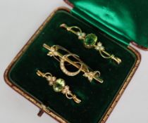 A Victorian peridot and seed pearl bar brooch set with a central oval faceted peridot and triplet