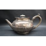A George V silver teapot, of compressed form with a half gadrooned body, Birmingham, 1909,