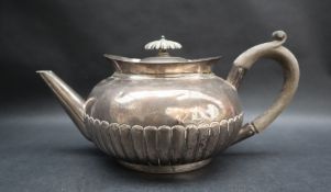 A George V silver teapot, of compressed form with a half gadrooned body, Birmingham, 1909,