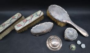 A George V silver trinket box and cover of oval form decorated with flowers and scrolls,