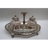 A Victorian silver desk standish of lobed oval form with a pierced border with central taper stick