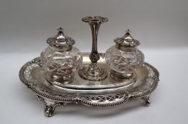 A Victorian silver desk standish of lobed oval form with a pierced border with central taper stick
