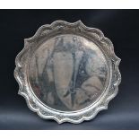 A late Victorian silver salver of circular form with a beaded edge,