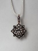 A Victorian diamond cluster pendant / brooch set with round old cut diamonds, to a diamond set bail,