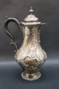 A late Victorian silver coffee pot of baluster form with embossed decoration of flowers,