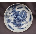 A Chinese porcelain bowl painted to the centre with a four toed dragon chasing a pearl amongst