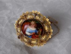 A yellow metal wirework brooch, set with a painted porcelain panel,