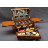 An oak cased and brass bound tantalus / games compendium, comprising three decanters,