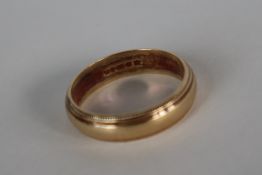 A 9ct gold wedding band with a beaded edge,