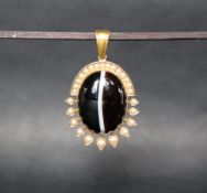 A Victorian yellow metal banded agate and seed pearl mourning pendant with a central domed agate