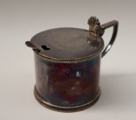 An Elizabeth II silver mustard pot and cover of cylindrical form with a leaf cast handle,