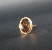 A 9ct gold dress ring set with an oval faceted smoky quartz, size Q, approximately 4.