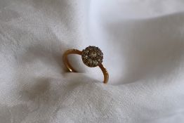 An 18ct gold diamond cluster ring set with a central round old cut diamond surrounded by eight