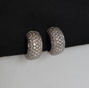 A pair of Leo Pizzo 18ct white gold diamond encrusted half hoop earrings,