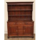An 18th century North Wales oak dresser with a moulded cornice and two shelves,