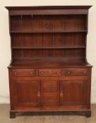 An 18th century North Wales oak dresser with a moulded cornice and two shelves,