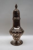 A late Victorian silver sugar caster with a flame finial and pierced domed cover above a baluster