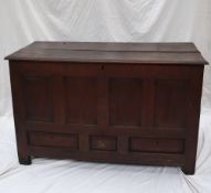 An 18th century oak coffer with a planked rectangular top above a four panel front and three