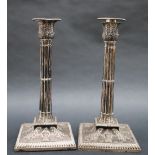 A pair of Victorian silver candlesticks, with a leaf cast top and cluster column on a square base,