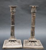 A pair of Victorian silver candlesticks, with a leaf cast top and cluster column on a square base,
