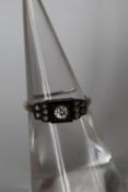 A diamond and onyx ring, set with a central old round cut diamond approximately 0.