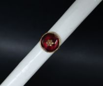 A 19th century yellow metal ring with central pearl and cabochon garnet,
