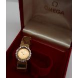 An 18ct yellow gold and diamond set lady's Omega wristwatch, the circular gilt dial with batons,