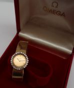An 18ct yellow gold and diamond set lady's Omega wristwatch, the circular gilt dial with batons,