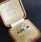 An opal and ruby ring set with four opals and a central ruby to an 18ct yellow gold setting and