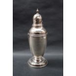 A George V silver sugar caster with a vase finial and domed cover with a tapering beaded body on a