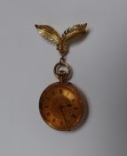 A 14k yellow gold fob watch with a gilt dial, Roman numerals and floral and leaf decorated centre,