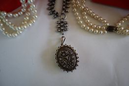 A Victorian white metal locket decorated with flowers and leaves and a beaded border together with