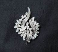 A diamond brooch of scrolling form, set with marquise,