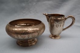 A continental white metal pedestal jug decorated with scrolls and leaves together with a matching