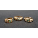 An 18ct yellow gold gypsy ring, set with two round faceted emeralds, size F 1/2,